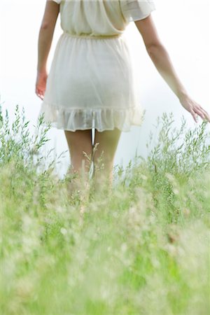 people walking rear view - Young woman walking through tall grass, cropped Stock Photo - Premium Royalty-Free, Code: 633-05401347