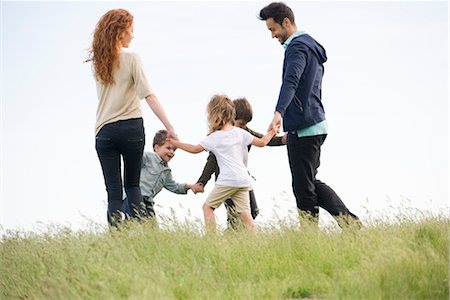 simsearch:633-05402022,k - Family playing ring-around-the-rosy in meadow Foto de stock - Royalty Free Premium, Número: 633-05401367