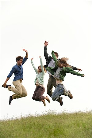 friends jumping outdoors - Young adults jumping on meadow Stock Photo - Premium Royalty-Free, Code: 633-05401513