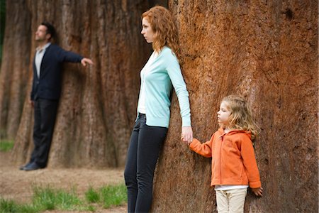 simsearch:632-05845573,k - Mère et fille adossée à arbre, père permanent distinct en arrière-plan Photographie de stock - Premium Libres de Droits, Code: 633-05401531