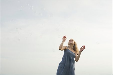 flotar - Young woman standing among floating bubbles Foto de stock - Sin royalties Premium, Código: 633-05401549