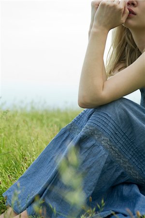 pensive woman profile - Young woman sitting in meadow, hands under chin, cropped Stock Photo - Premium Royalty-Free, Code: 633-05401558