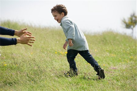 Little boy running toward adult's arms Stock Photo - Premium Royalty-Free, Code: 633-05401601