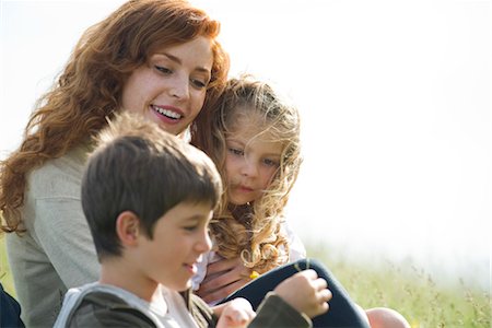 Mother and two children relaxing together outdoors Stock Photo - Premium Royalty-Free, Code: 633-05401635