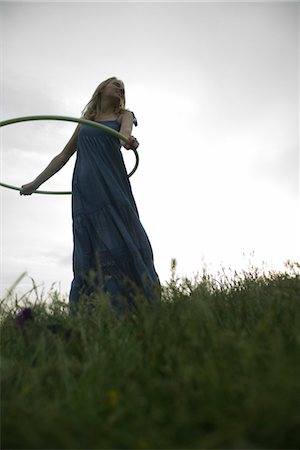 simsearch:633-05402126,k - Young woman playing with plastic hoop outdoors Stock Photo - Premium Royalty-Free, Code: 633-05401654