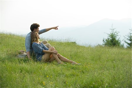 point - Couple sitting on meadow, man pointing toward distance Stock Photo - Premium Royalty-Free, Code: 633-05401653