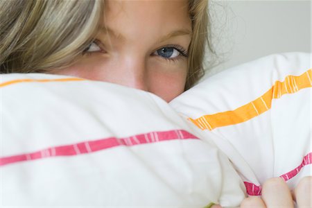 embarrassed - Young woman hiding face in pillow, portrait Stock Photo - Premium Royalty-Free, Code: 633-05401673