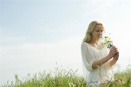 summer flower bouquets - Young woman smelling bouquet of wildflowers Stock Photo - Premium Royalty-Free, Code: 633-05401683