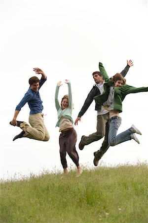 Young adults jumping on meadow Stock Photo - Premium Royalty-Free, Code: 633-05401703