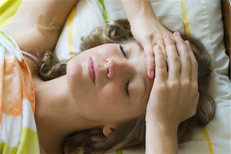 simsearch:632-03847818,k - Young woman lying in bed with hands clasped on forehead Stock Photo - Premium Royalty-Free, Code: 633-05401750