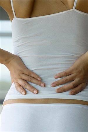 person with cramps - Woman experiencing lower back pain, cropped Stock Photo - Premium Royalty-Free, Code: 633-05401803