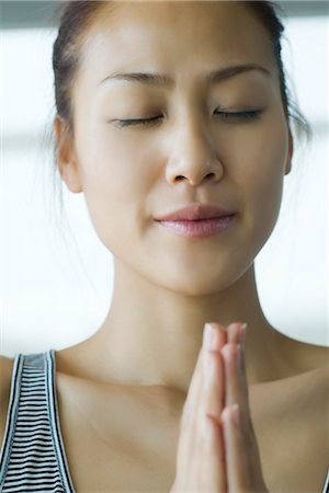 Young woman holding hands in prayer position Stock Photo - Premium Royalty-Free, Code: 633-05401831