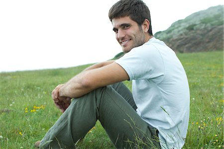 sideways glance - Man sitting on meadow, portrait Stock Photo - Premium Royalty-Free, Code: 633-05401899