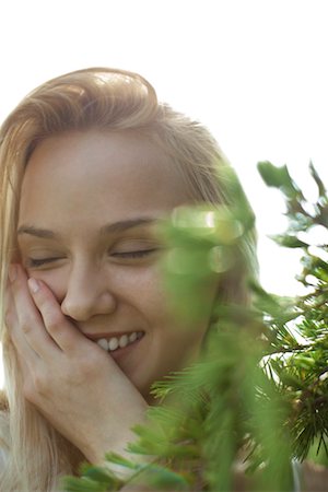 simsearch:633-06406668,k - Young woman in nature, smiling with eyes closed Stock Photo - Premium Royalty-Free, Code: 633-05401918
