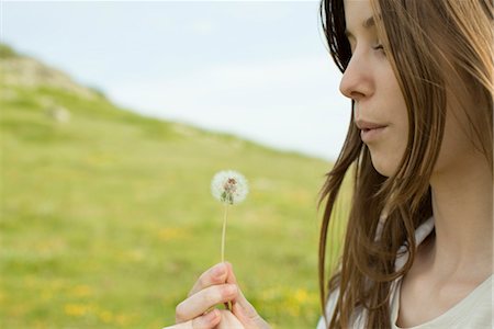 simsearch:633-05401584,k - Young woman blowing on dandelion clock Stock Photo - Premium Royalty-Free, Code: 633-05401928
