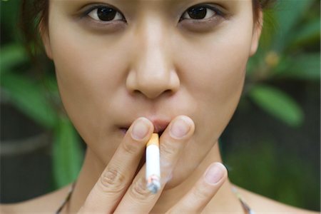 simsearch:632-02744691,k - Young woman smoking outdoors Foto de stock - Sin royalties Premium, Código: 633-05401941