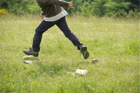 profile of boy jumping - Boy running in field, low section Stock Photo - Premium Royalty-Free, Code: 633-05401956