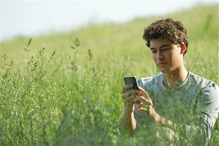 simsearch:400-08997106,k - Young man text messaging in nature Stock Photo - Premium Royalty-Free, Code: 633-05401964