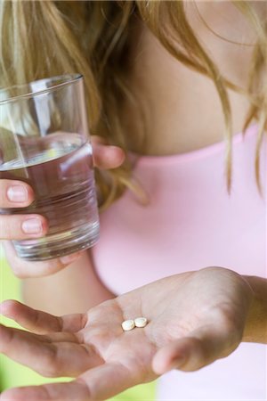 person cupping water - Young woman holding vitamins and glass of water Stock Photo - Premium Royalty-Free, Code: 633-05402001