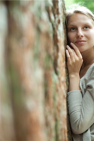 simsearch:633-05401416,k - Young woman leaning against tree Stock Photo - Premium Royalty-Free, Code: 633-05402027