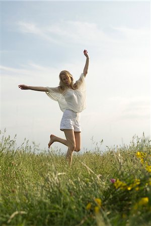 Young woman jumping in meadow Stock Photo - Premium Royalty-Free, Code: 633-05402095