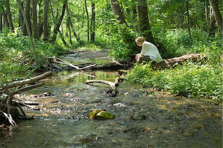 Jeune femme assise de rivière traversant les bois Photographie de stock - Premium Libres de Droits, Code: 633-05402133