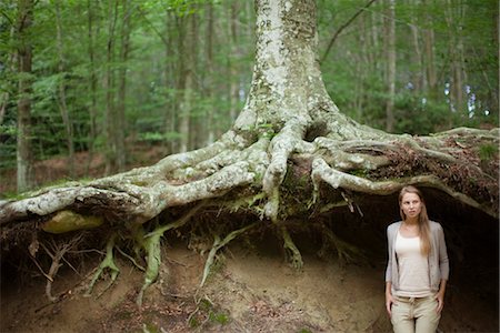 scale (contrast in size) - Woman standing at base of tree in woods, looking away in thought Stock Photo - Premium Royalty-Free, Code: 633-05402150