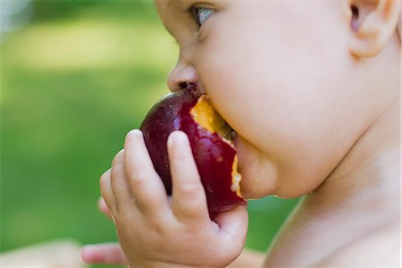 Baby girl eating plum, side view Foto de stock - Sin royalties Premium, Código: 633-06322289