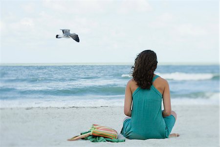 seagulls at beach - Teenage girl sitting on beach looking at ocean, rear view Stock Photo - Premium Royalty-Free, Code: 633-06322296