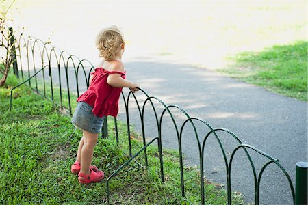 Baby girl standing by fence Foto de stock - Sin royalties Premium, Código: 633-06322290
