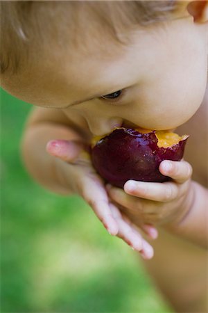 Baby girl eating plum, cropped Foto de stock - Sin royalties Premium, Código: 633-06322314