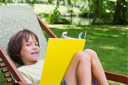 deckchair garden - Boy reclining in deckchair with book Stock Photo - Premium Royalty-Free, Code: 633-06322370