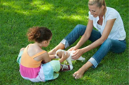 Mère et fille, assis sur l'herbe, jouer avec les chiots beagle Photographie de stock - Premium Libres de Droits, Code: 633-06322453