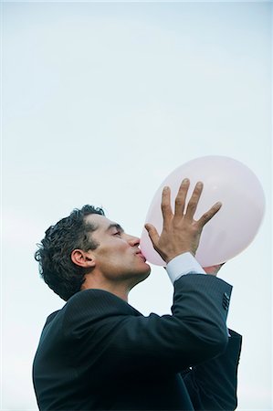 Businessman blowing up balloons Stock Photo - Premium Royalty-Free, Code: 633-06322650