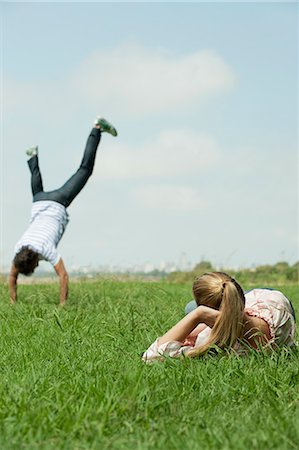 Woman lying in grass, watching man do handstand Foto de stock - Sin royalties Premium, Código: 633-06354623