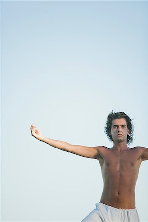 simsearch:632-06317105,k - Jeune homme pracicing yoga avec bras tendus Photographie de stock - Premium Libres de Droits, Code: 633-06354674