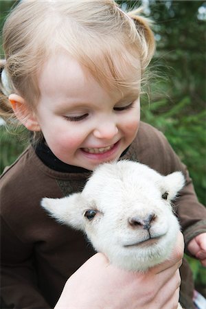 Little girl petting lamb Foto de stock - Sin royalties Premium, Código: 633-06354688