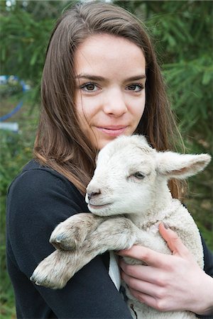 Teenage girl holding lamb Foto de stock - Royalty Free Premium, Número: 633-06354767