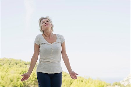 Mature woman rolling neck outdoors with eyes closed Stock Photo - Premium Royalty-Free, Code: 633-06354918