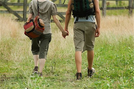 Couple walking in field holding hands, rear view Stock Photo - Premium Royalty-Free, Code: 633-06354911