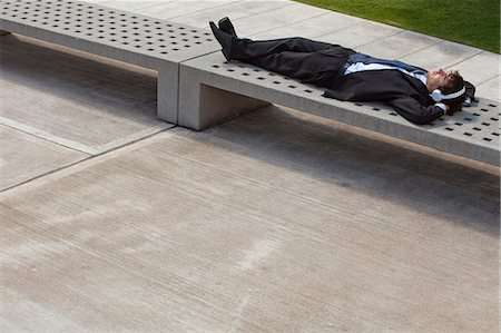 single loaf - Young businessman napping on park bench with headphones on Stock Photo - Premium Royalty-Free, Code: 633-06354913