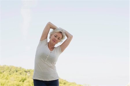 Mature woman stretching with eyes closed Stock Photo - Premium Royalty-Free, Code: 633-06355076