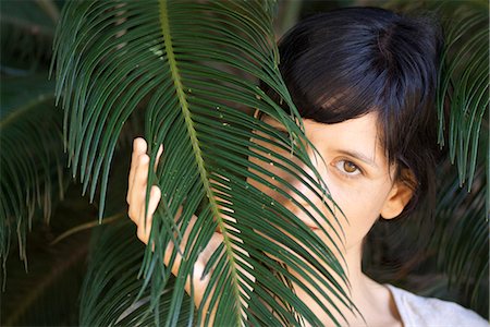 simsearch:633-06406668,k - Young woman looking through palm leaf, portrait Stock Photo - Premium Royalty-Free, Code: 633-06406707