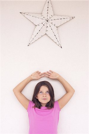 reflection of star to human - Girl standing beneath star decoration, daydreaming, portrait Stock Photo - Premium Royalty-Free, Code: 633-08150772