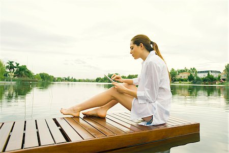 relaxing tablet lake - Woman relaxing on lake dock using digital tablet Stock Photo - Premium Royalty-Free, Code: 633-08150877