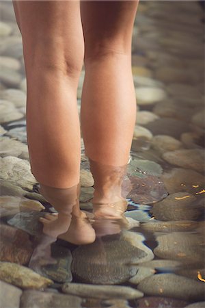 simsearch:633-08150888,k - Woman walking in wading pool, low section Fotografie stock - Premium Royalty-Free, Codice: 633-08150890