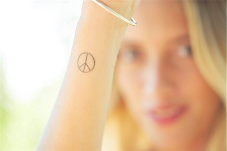 peace sign and woman - Woman with peace sign tattoo on her wrist Stock Photo - Premium Royalty-Free, Code: 633-08150901