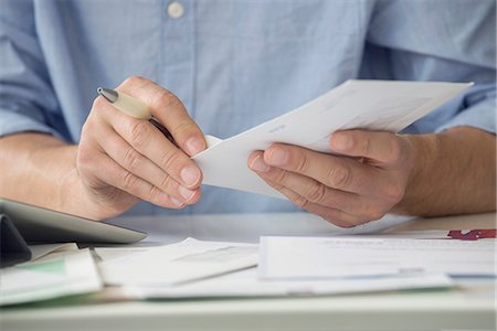 paying bills - Man opening mail Stock Photo - Premium Royalty-Free, Code: 633-08638877