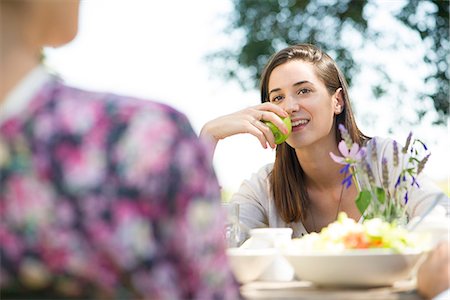 simsearch:633-08726159,k - Woman enjoying meal outdoors with friends Stock Photo - Premium Royalty-Free, Code: 633-08638871