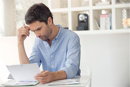 Man frustrated by mounting debt Stock Photo - Premium Royalty-Free, Code: 633-08638873